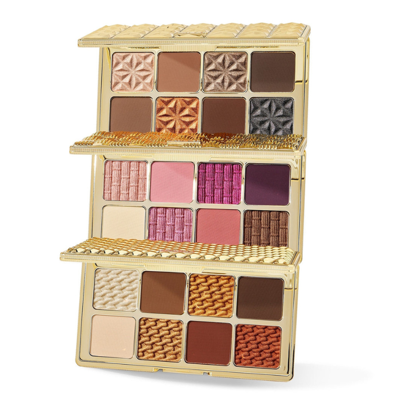 A gold-colored, multi-level eye shadow palette featuring a variety of colors with both matte and shimmery finishes.