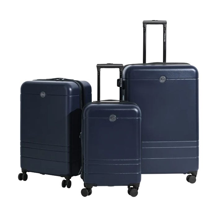 Three navy blue hard-shell suitcases of varying sizes with telescopic handles and four spinner wheels.