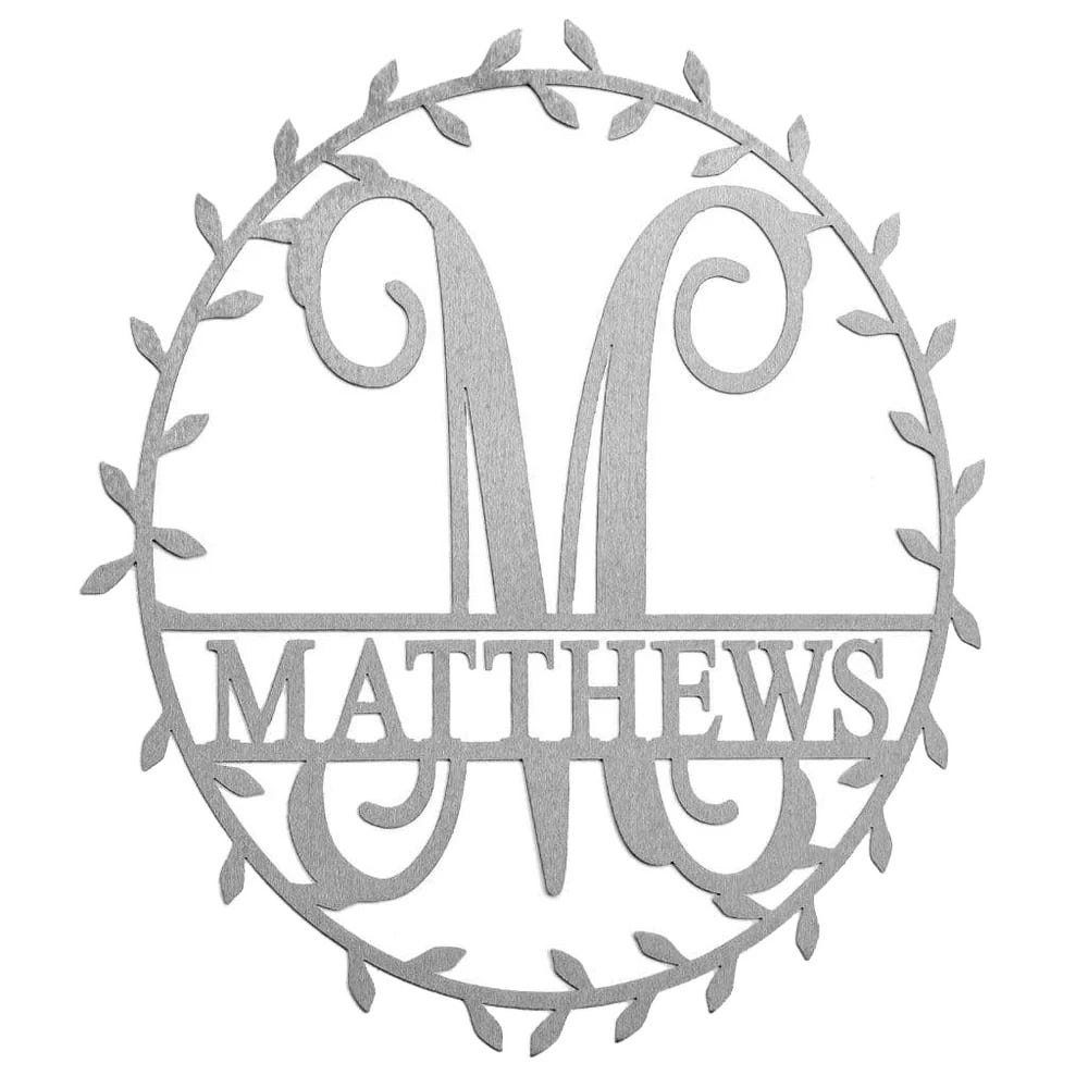 A circular metal monogram sign features the letter \“M\“ with \“MATTHEWS\“ written across it, surrounded by a decorative leaf design.