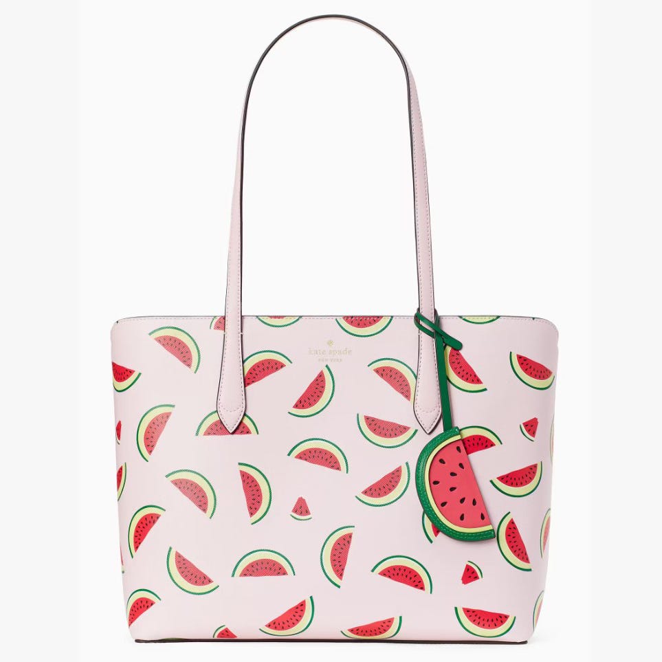 A pink tote bag with watermelon slice pattern and a green watermelon slice charm.