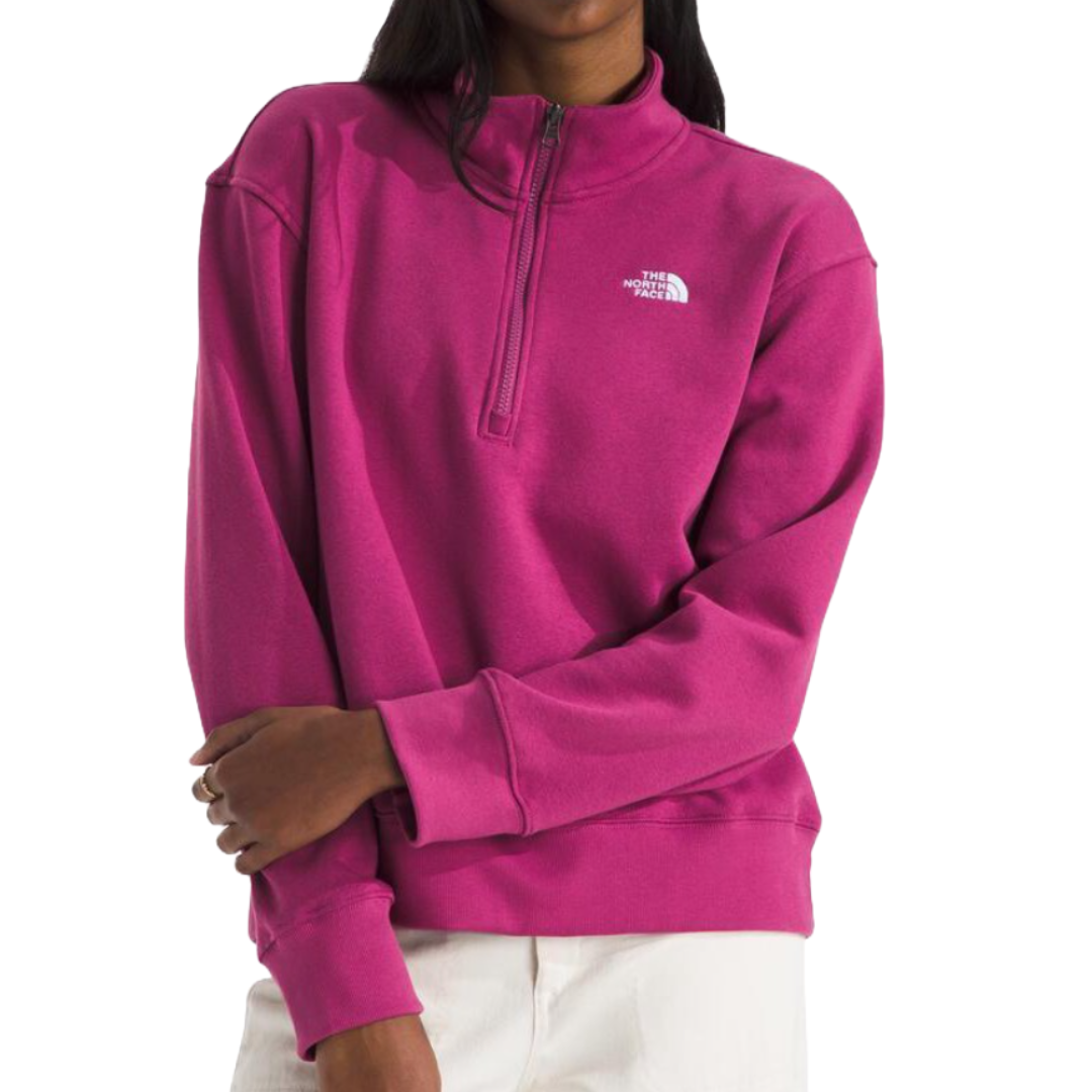 A fuchsia quarter-zip sweatshirt featuring \“The North Face\“ logo on the chest, paired with white pants.