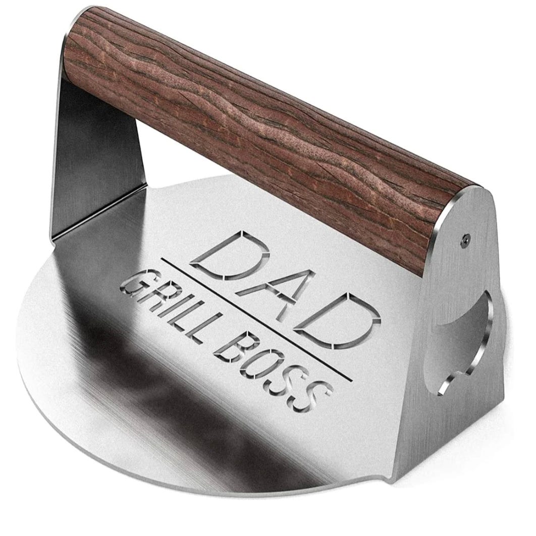 Stainless steel BBQ press with a wooden handle, featuring the engraved text \“Dad Grill Boss.\“ Ideal for grilling, it helps press down food for even cooking.