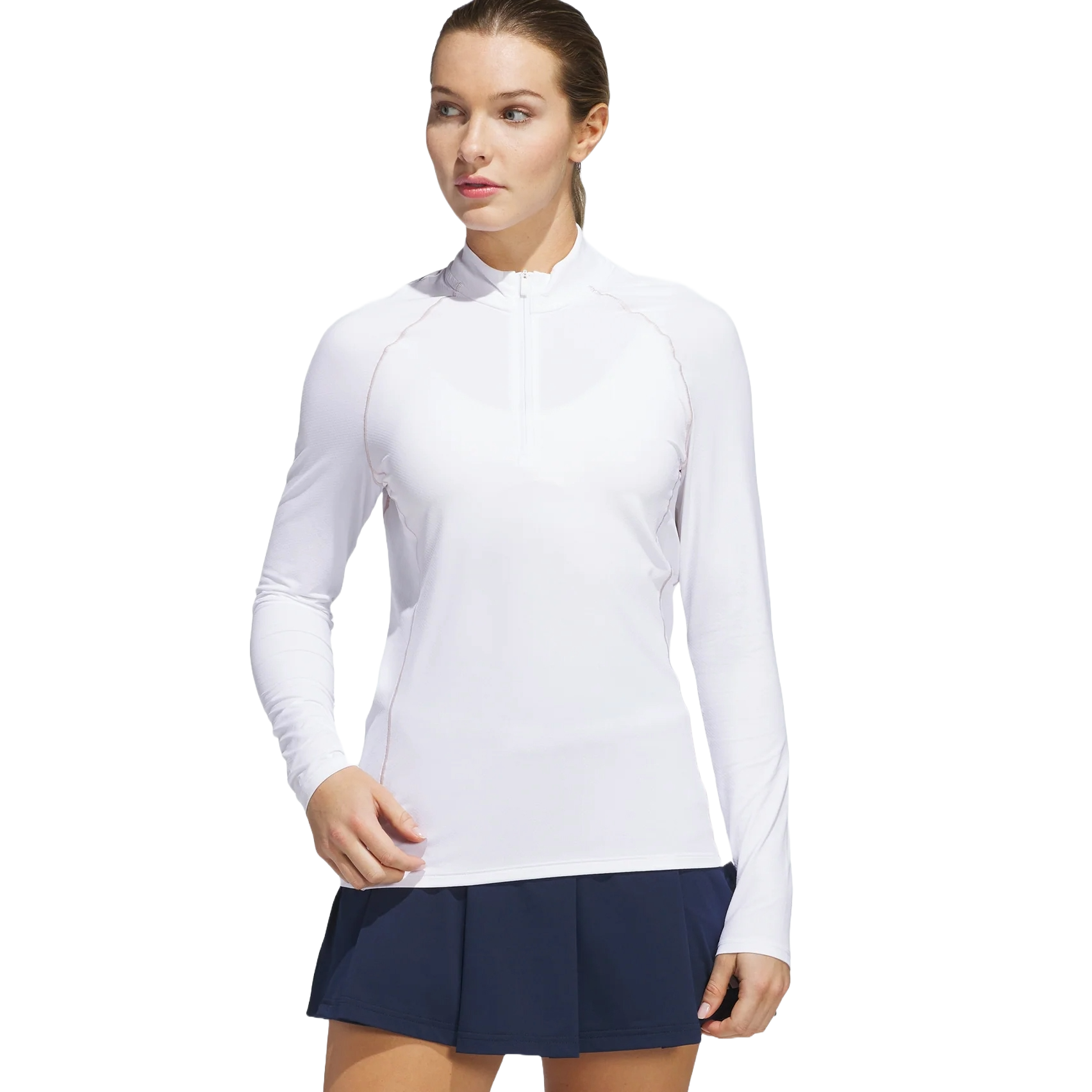 A woman is wearing a white long-sleeve athletic top with a quarter-zip and a navy pleated skirt.