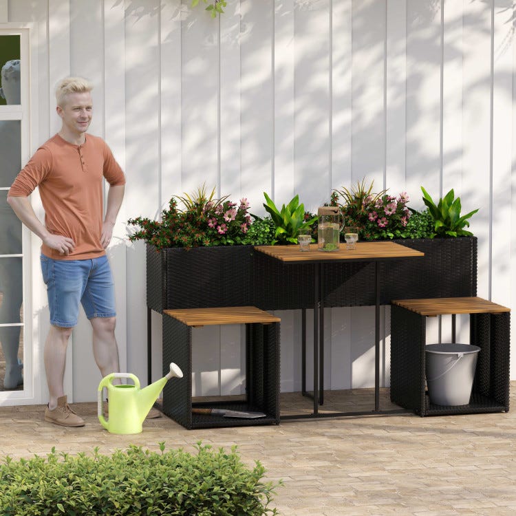 Outdoor seating set with planters, including a small table, two stools with wooden tops, and surrounded by flowers and plants. A watering can and bucket are nearby.
