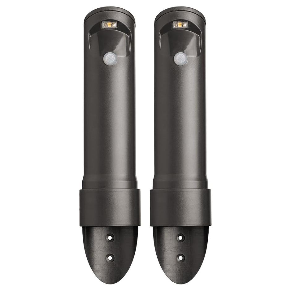 Two dark-colored outdoor wall-mounted lights with a cylindrical design, featuring motion sensors and LED bulbs.