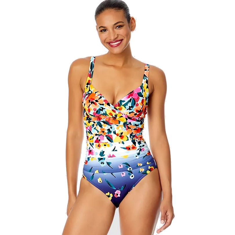 Colorful one-piece swimsuit with a floral pattern on top transitioning to blue with small flowers at the bottom. V-neck design with wide straps.