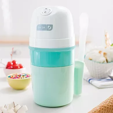 A compact ice cream maker with a mint green base and white top, featuring a simple control button and accompanied by a matching scoop.