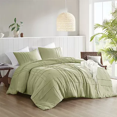 Olive green queen comforter set featuring pleated design with two shams, staged in a bright bedroom.