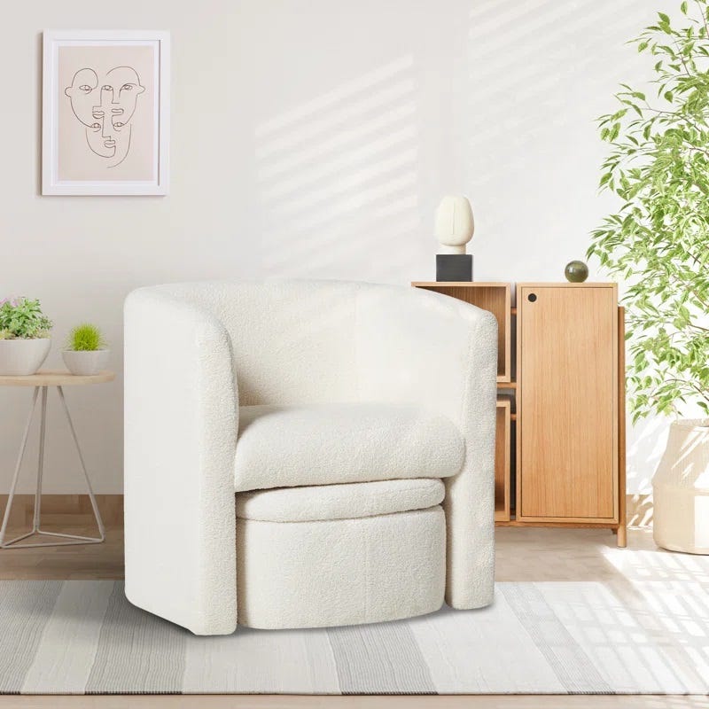 A plush white armchair, a wooden cabinet, and decorative plants in a bright room.