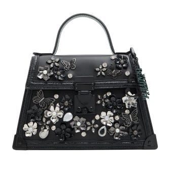 Black satchel with a top handle, adorned with floral and butterfly embellishments in silver and black, featuring a lock closure and decorative charm.