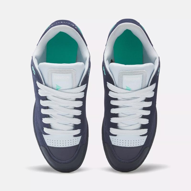 A pair of Reebok sneakers in navy blue with white laces and a teal accent.