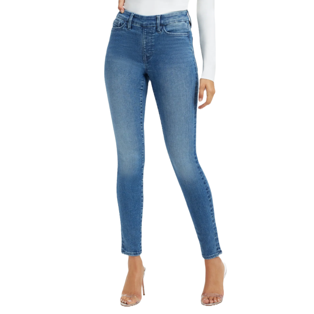 Blue skinny jeans with a high-waisted fit, subtle fading, and five-pocket styling, paired with clear high-heeled sandals.