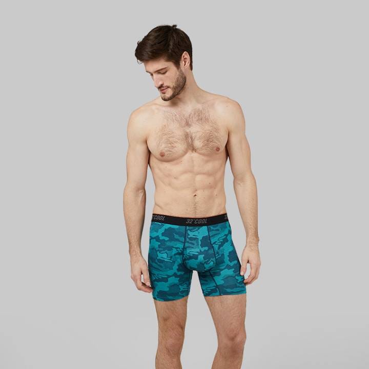 A man is wearing blue camo-patterned boxer briefs.