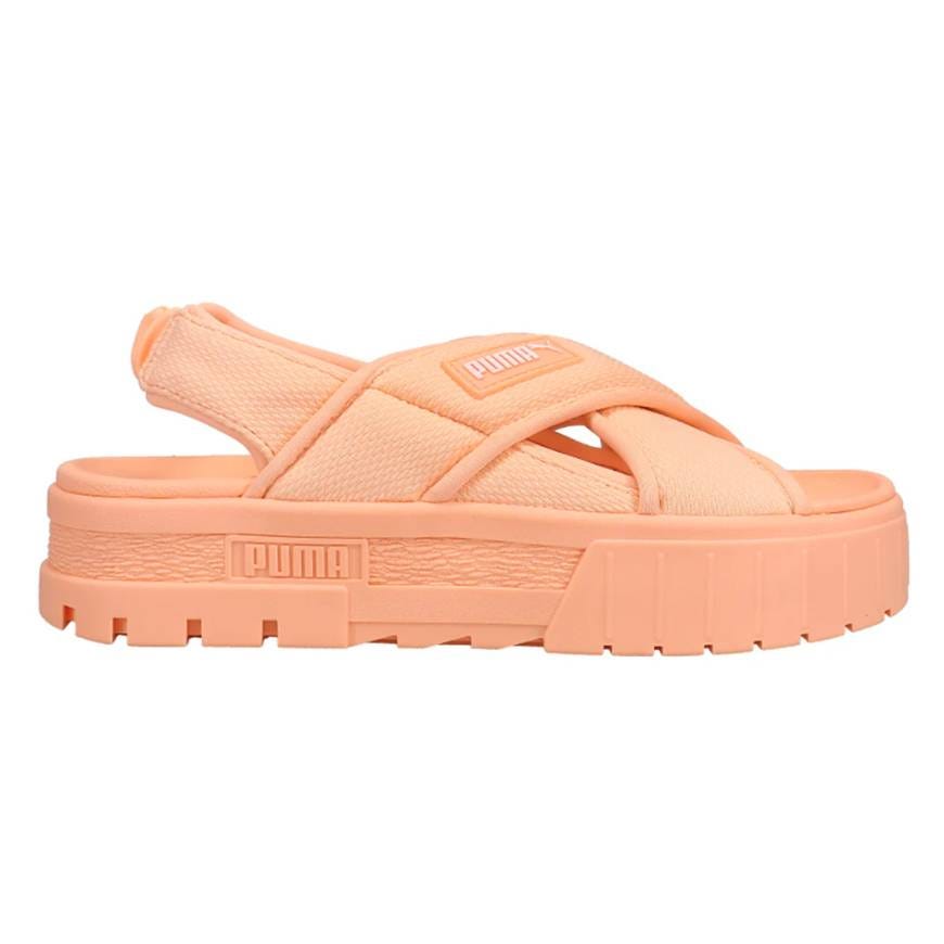 Peach-colored Puma sandal with a thick sole and adjustable strap, featuring a cross-band design and brand logo on the side.