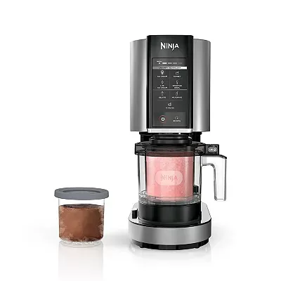 Ninja Creami ice cream maker with a black and silver body, featuring a touchscreen panel, comes with a pint-sized freezing container.