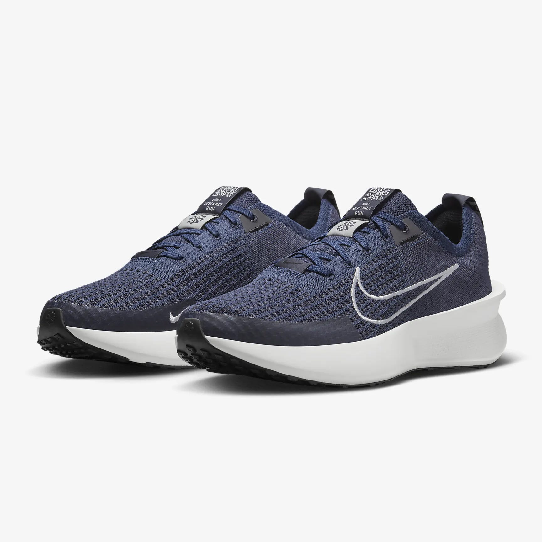 A pair of dark blue running shoes with a white swoosh logo and a white sole.