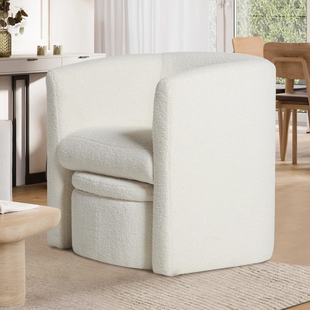 A minimalist cream-colored armchair with a textured fabric.