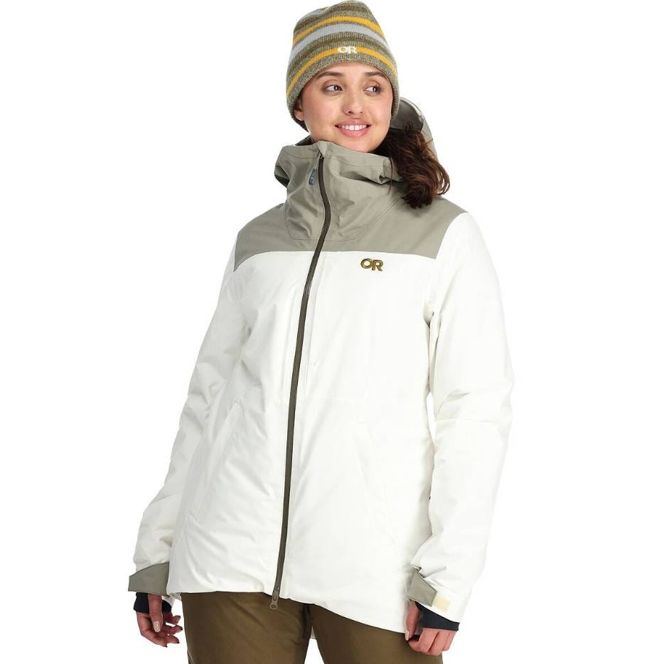 The Snowcrew Jacket is an insulated, waterproof jacket with a two-tone design featuring a light beige top and white body. It includes a hood and is paired with a striped beanie. The jacket has a front zipper and hand pockets.