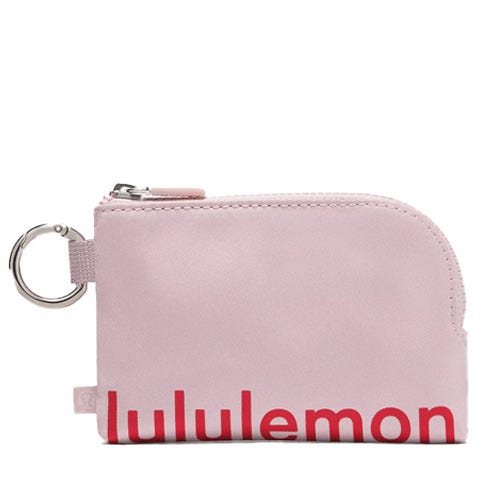 A small, pink Lululemon pouch with a zipper and keyring attachment, featuring the Lululemon logo in red text.