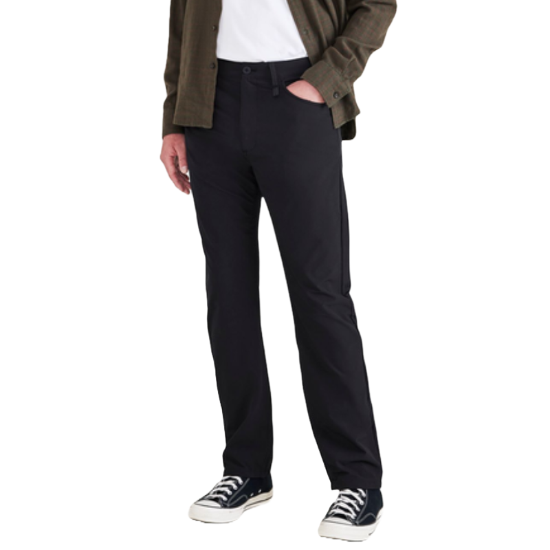 A person is wearing black pants paired with a white T-shirt, an olive-green button-up shirt, and black-and-white sneakers.