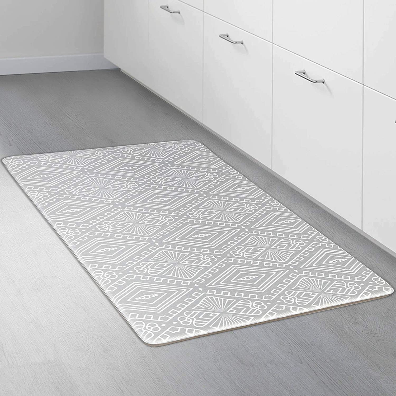 A rectangular kitchen mat with a geometric pattern on a wooden floor.