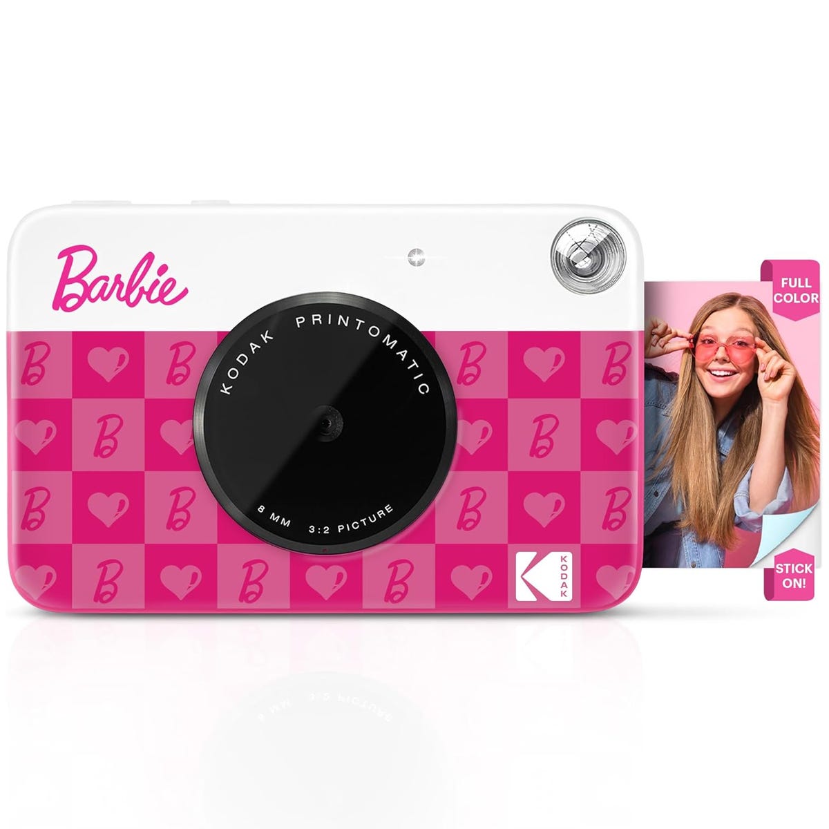 Kodak Printomatic camera with a Barbie-themed pink design featuring hearts and \“B\“ motifs. A sample photo shows a person wearing pink sunglasses with the label \“FULL COLOR STICK ON!\“