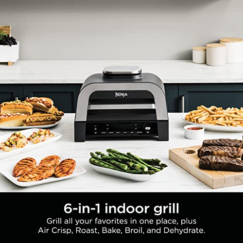 Ninja Foodi XL Cooker is a 6-in-1 indoor grill for various cooking methods including Air Crisp, Roast, Bake, Broil, and Dehydrate, presented with different foods prepared on a kitchen counter.
