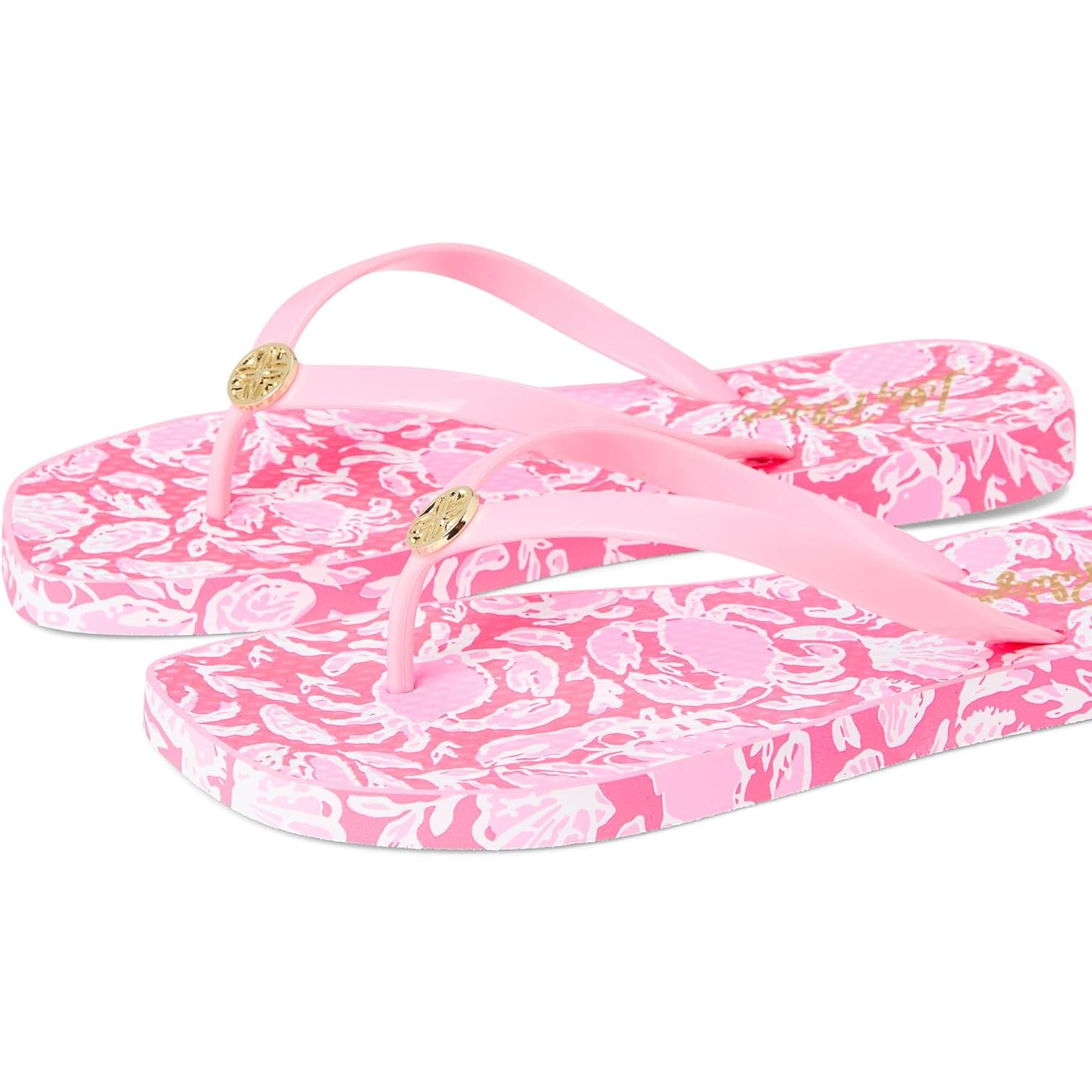 Pink flip-flops featuring a floral pattern, with gold accents on the straps, providing a stylish and vibrant design.