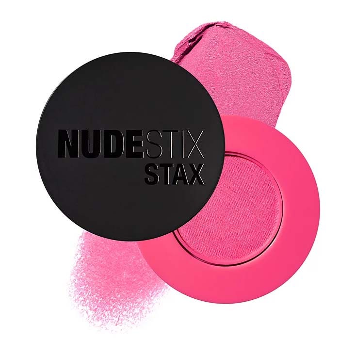 NudeStix Stax features a vibrant pink blush with a black circular lid displaying the brand name.