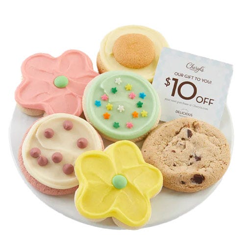 A plate featuring six cookies: colorful flower-shaped and round cookies with various frosting designs, including chocolate chip and pastel icing. A $10 discount card from Cheryl's is also included.