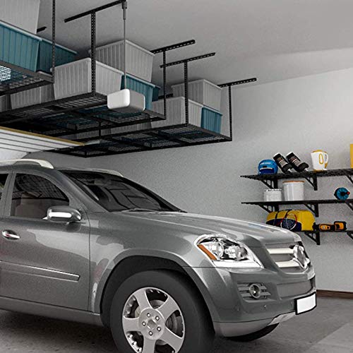Overhead garage racks are suspended shelving units used for storage, freeing up floor space in a garage where a silver car is parked.