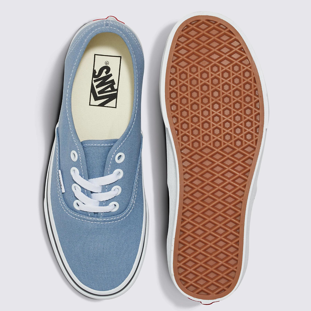 A pair of blue canvas sneakers with white laces and a brown rubber sole.