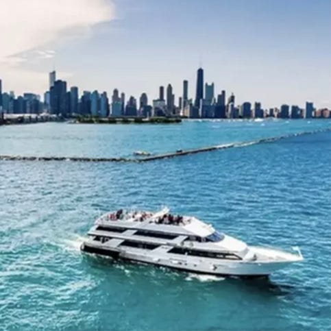A yacht on water with a city skyline in the background.