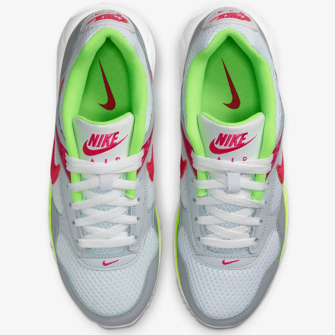 A pair of Nike Air sneakers with white laces, grey mesh, neon green inner lining, and red Nike swoosh logos.