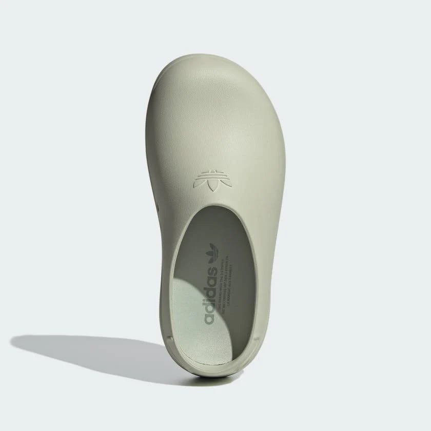 Pale green slip-on shoe with a logo on the insole and a small logo detail on the heel.
