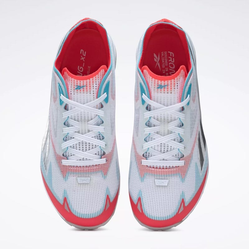 A pair of athletic shoes with white, blue, and red accents, featuring a front lace-up design and mesh upper.