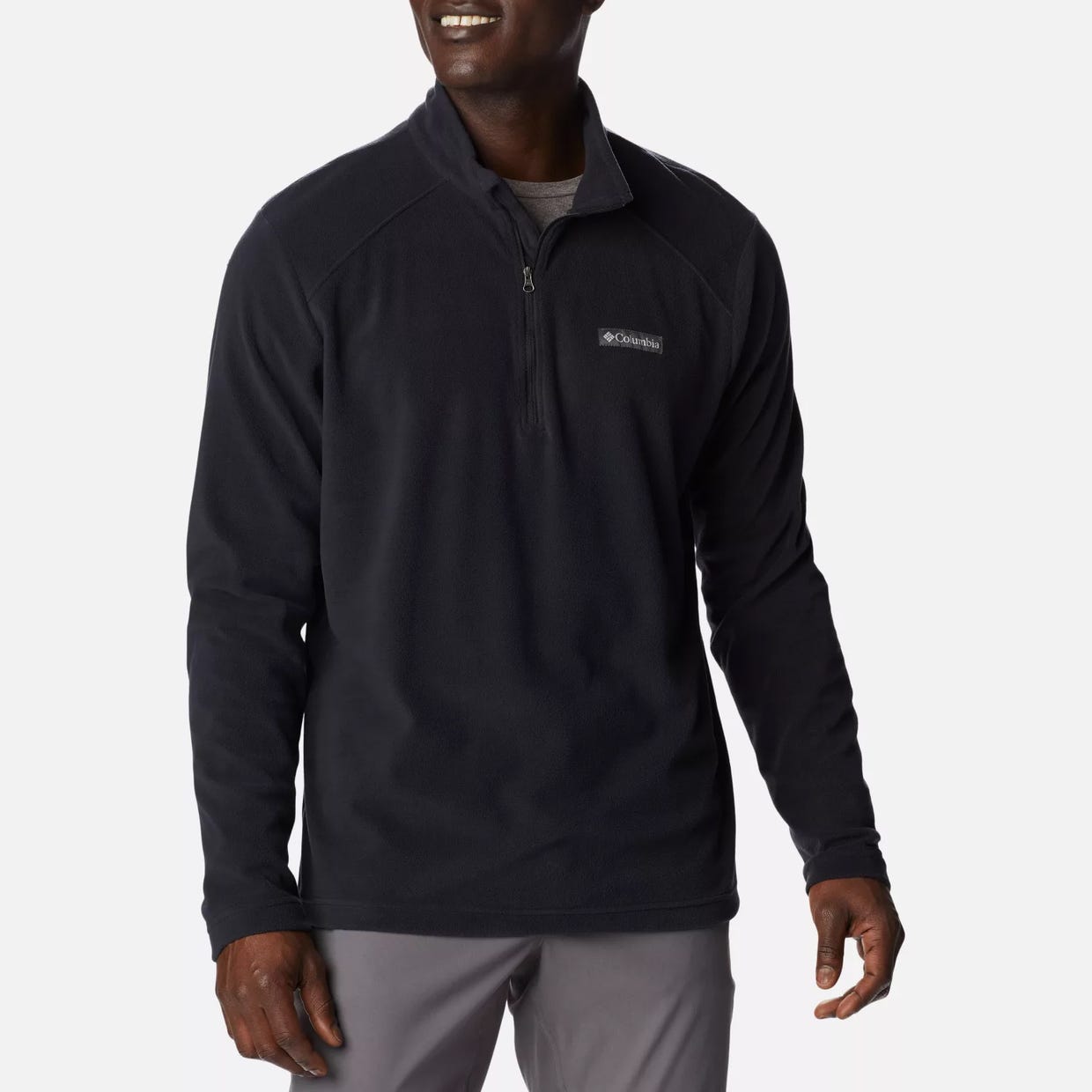 A man wearing a black quarter-zip fleece pullover with a logo on the chest.