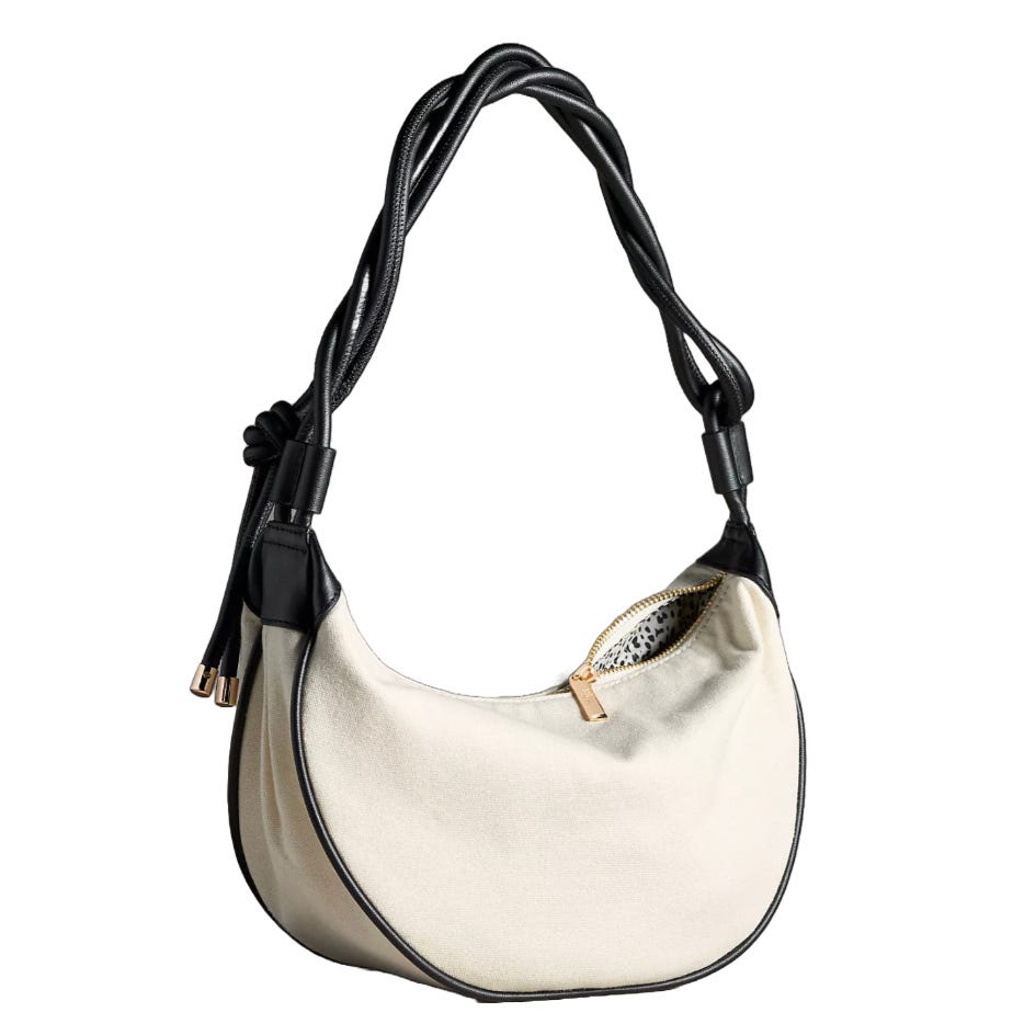 A white shoulder bag with black trim and a twisted rope strap, featuring a zippered opening and small metal accents.