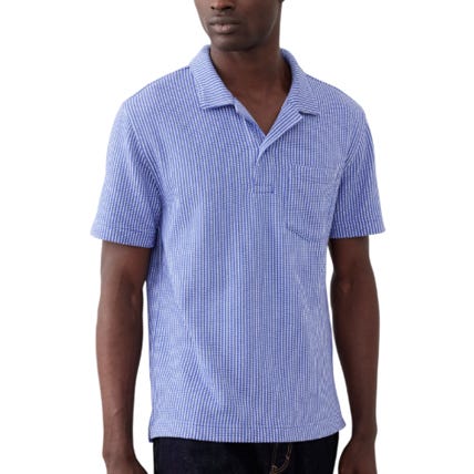 A short-sleeve blue seersucker polo with a spread collar, featuring a textured stripe pattern and a single chest pocket.