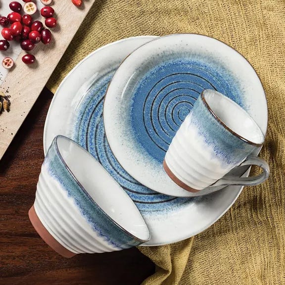 This is a set of ceramic dinnerware with blue and white glazing, including plates and a mug.