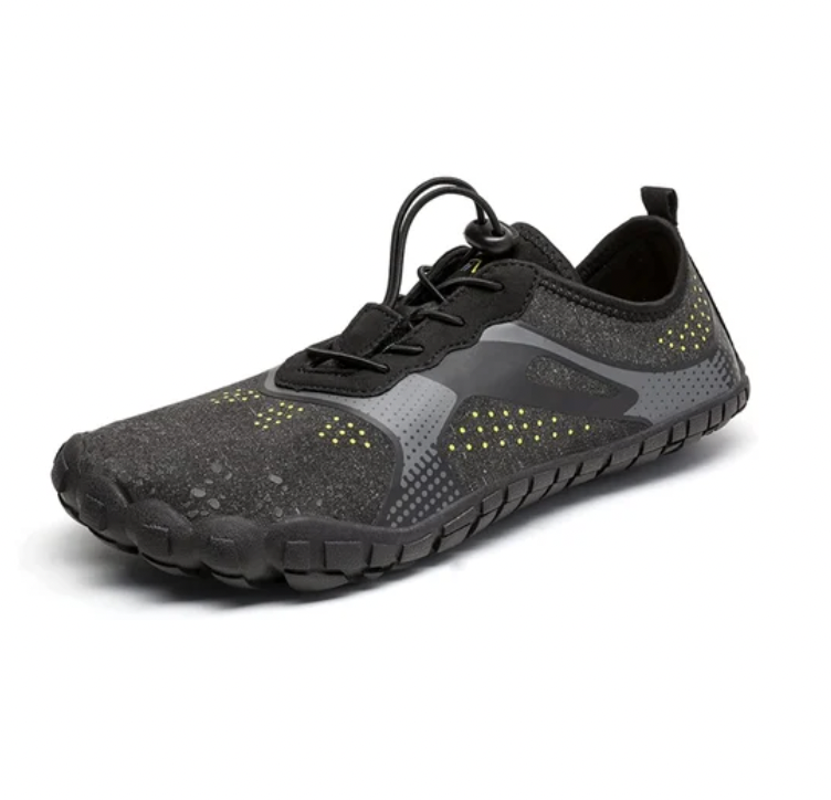 A pair of dark athletic shoes with yellow dot patterns and a loop on the heel.