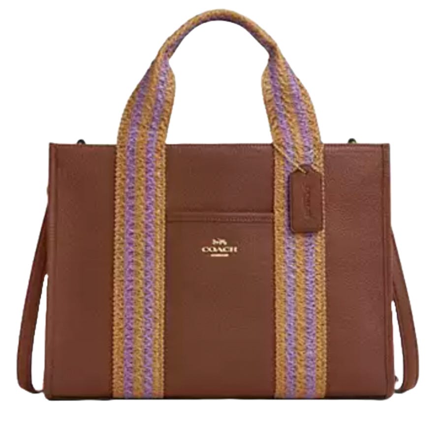 A brown Coach tote bag with purple and gold striped handles, featuring a front pocket with a Coach logo and a hanging tag.