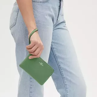 A person holding a green wallet.