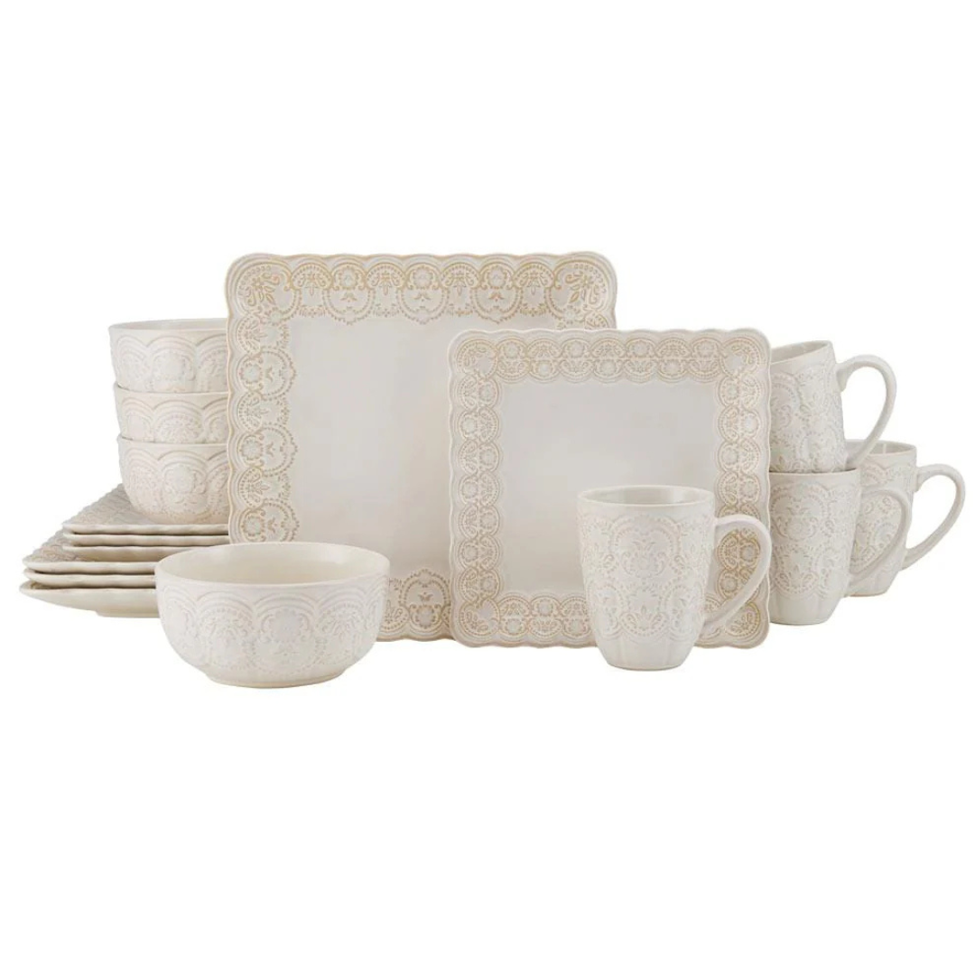 Square dinnerware set featuring ornate detailing, including plates, bowls, and mugs in an ivory color with decorative edging.