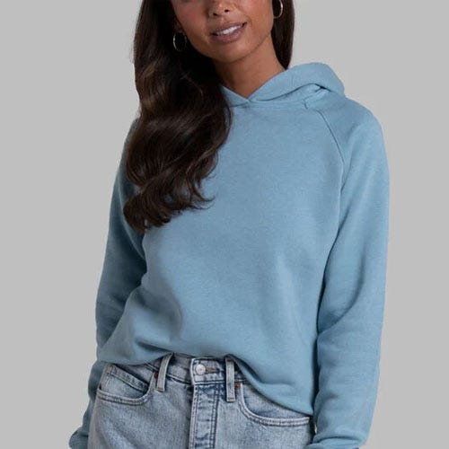 A woman is wearing a light blue hoodie and blue denim jeans.