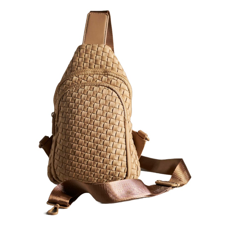 Tan woven sling bag with multiple zippered compartments and an adjustable brown strap.