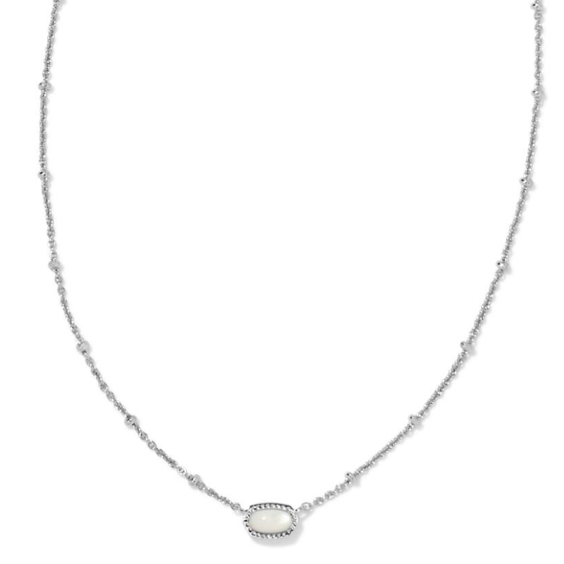 A delicate silver necklace featuring a dainty chain adorned with small beads and a central oval pendant with a polished white stone encircled by a beaded border.