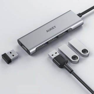A USB-C hub with multiple ports and two USB flash drives next to it.