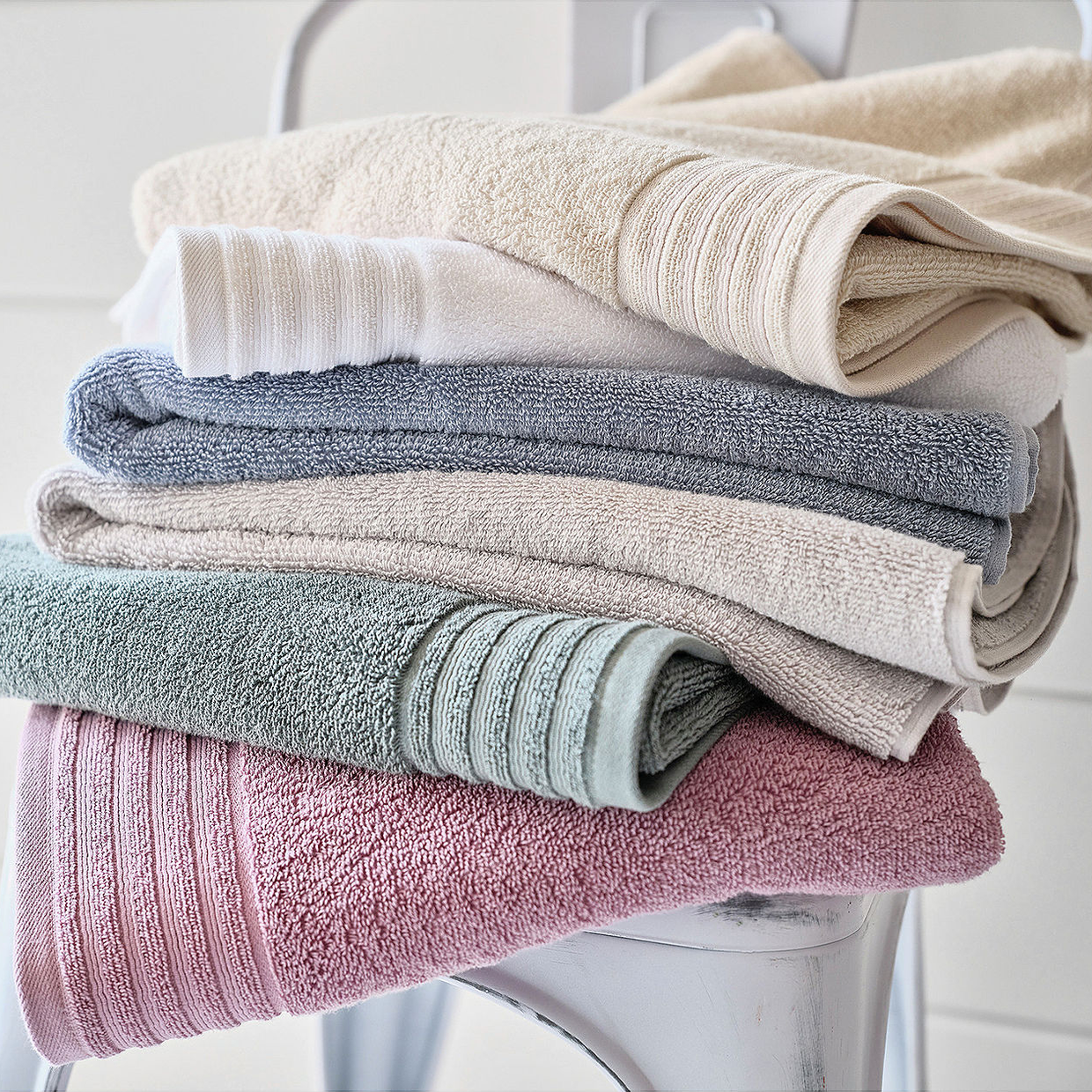A stack of folded towels in various pastel colors.