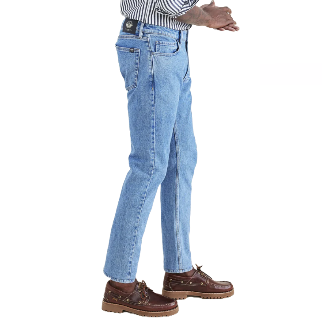 Light blue denim jeans with a classic straight-leg fit, featuring a black back patch and paired with brown boat shoes and a striped shirt.